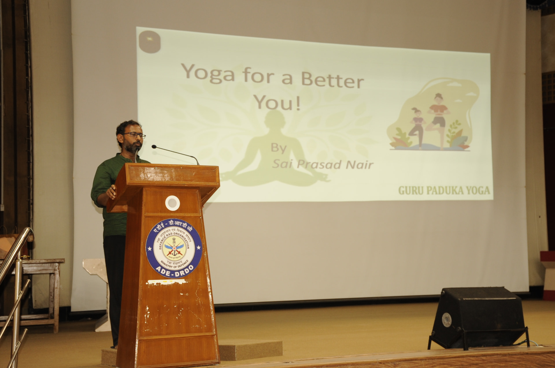 Sai Prasad Nair at the podium, opening the session titled 'Yoga for a Better You!'