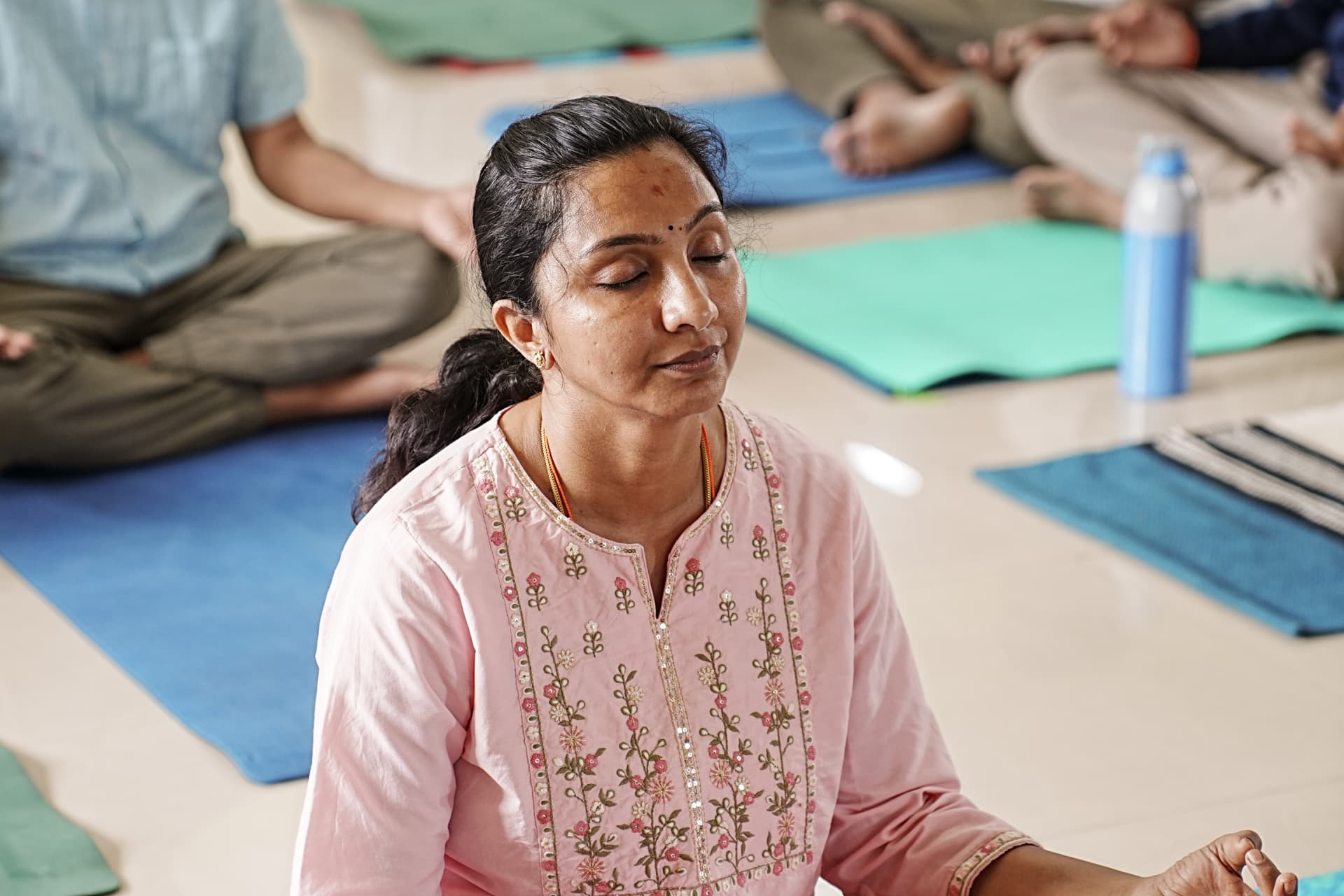 A student meditating with eyes closed in a group session