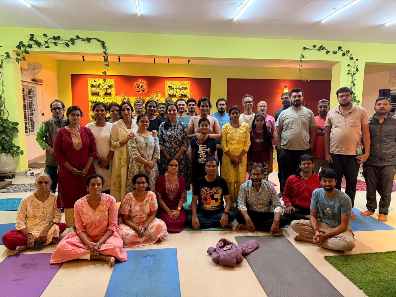 Students and teachers posing together inside the Guru Paduka studio after a class