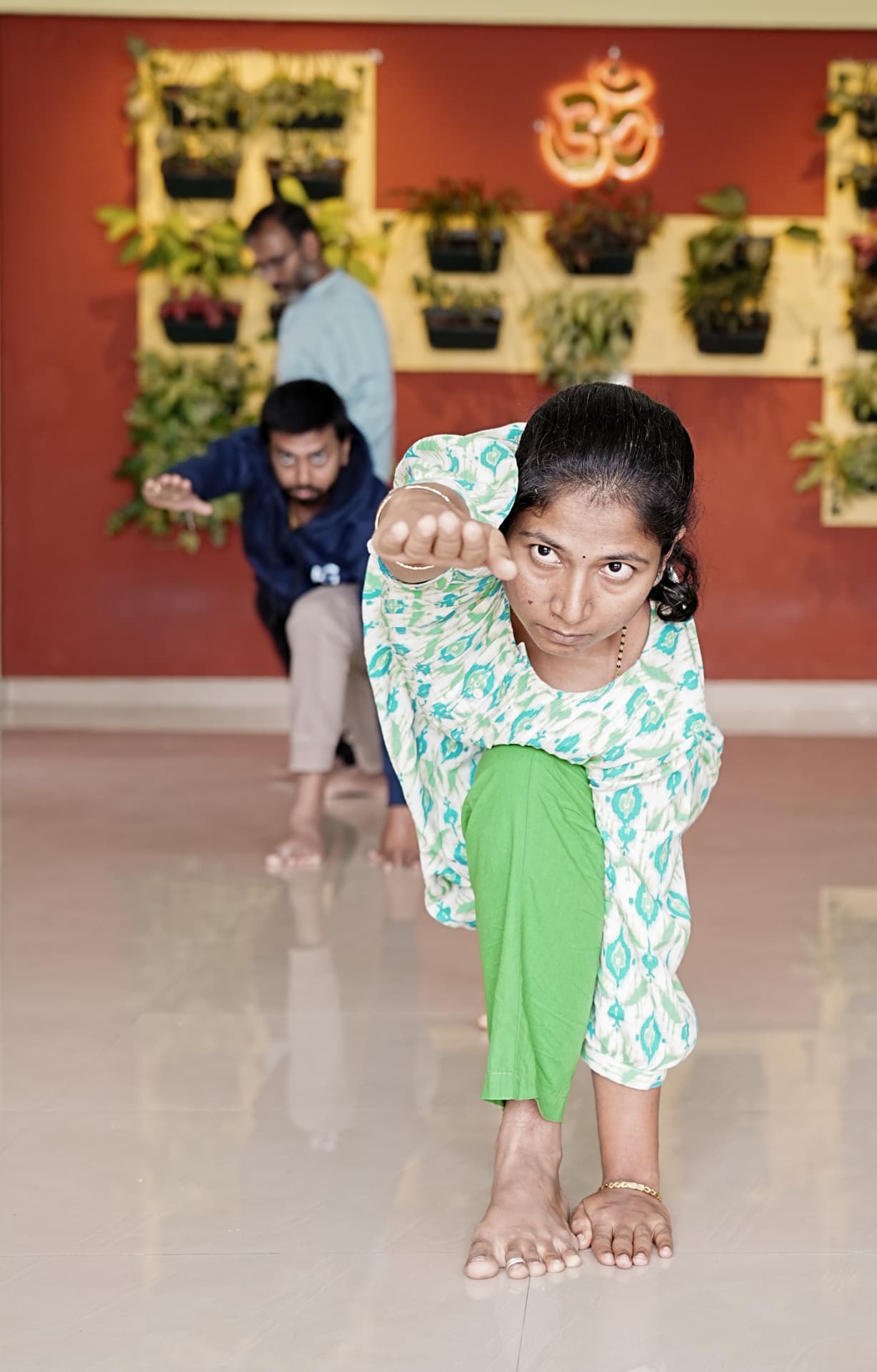 A student holding a balancing posture in the Guru Paduka practice hall
