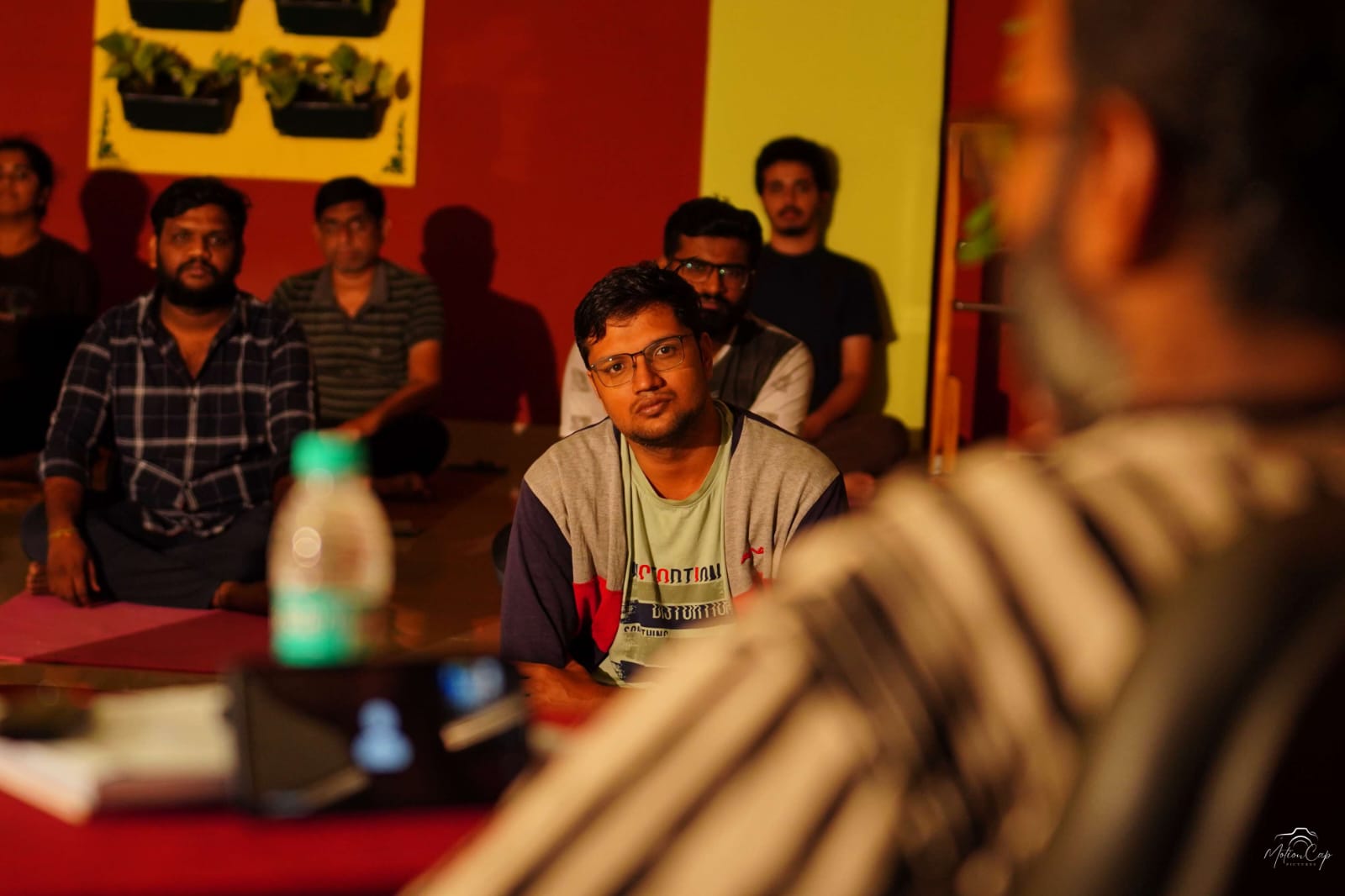 A group gathered for satsang in the warm studio light