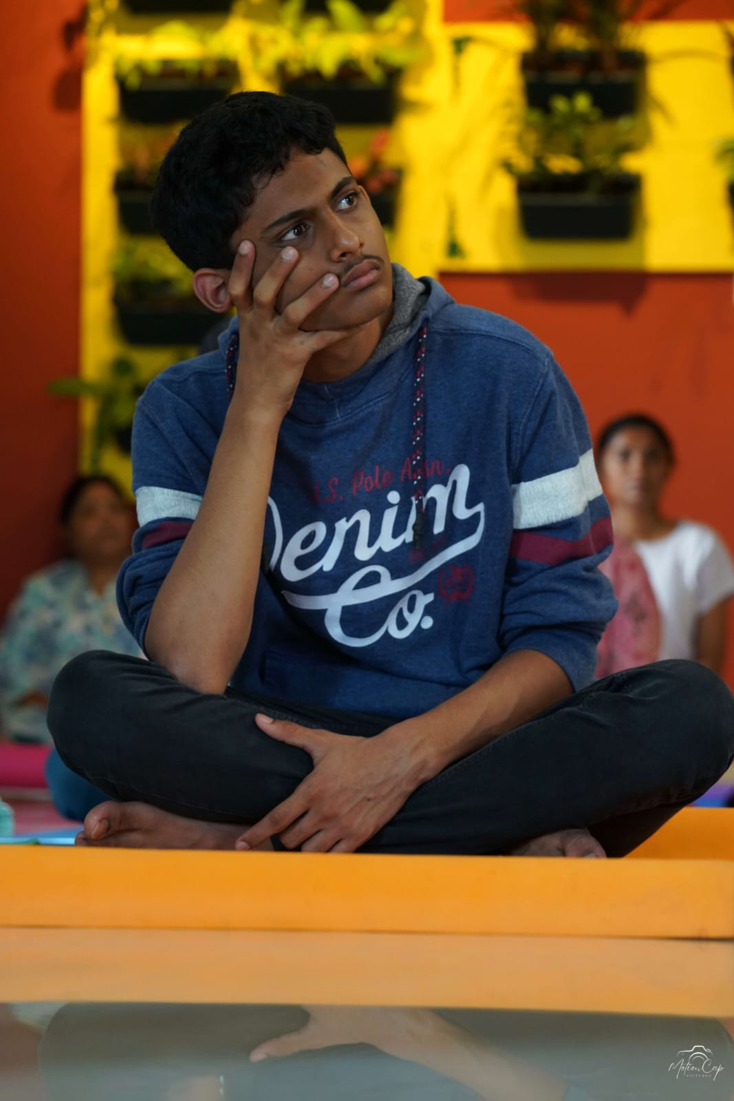 A young student seated in contemplation during a group session