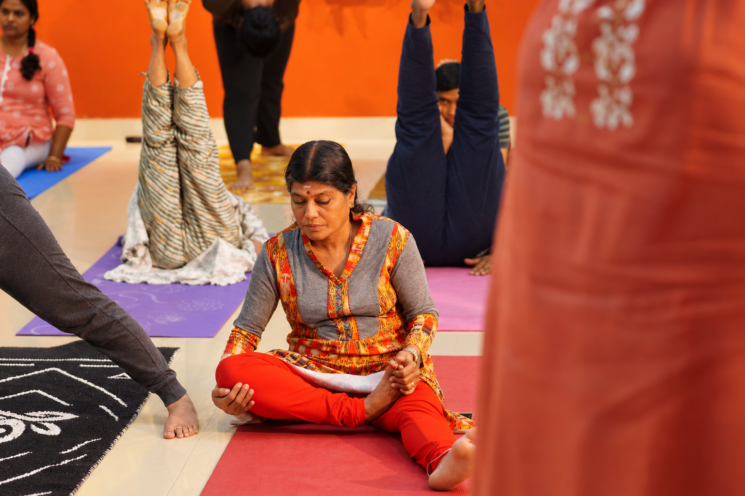 A student in a seated hip-opening posture during a group class