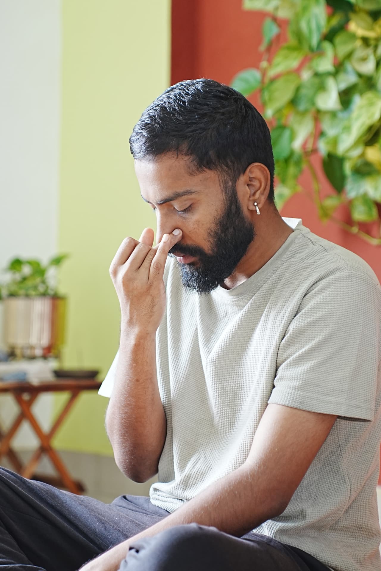 A practitioner seated while practising alternate-nostril breathing