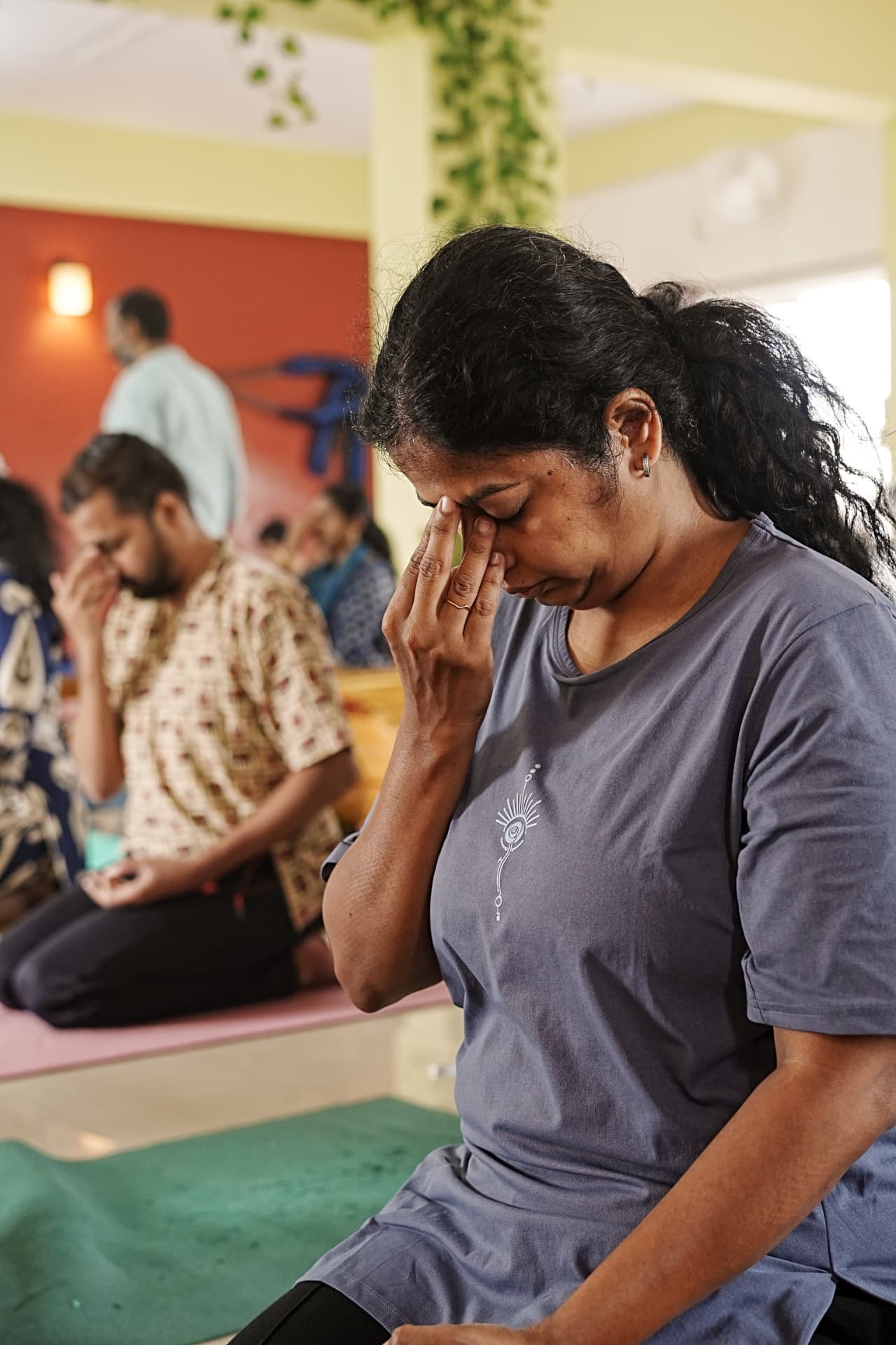 Students practising alternate nostril breathing in a sunlit hall