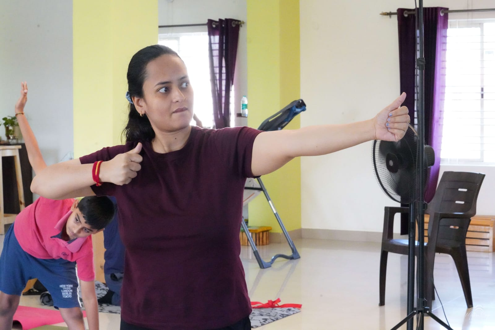 A student stretching one arm across the chest in a group class