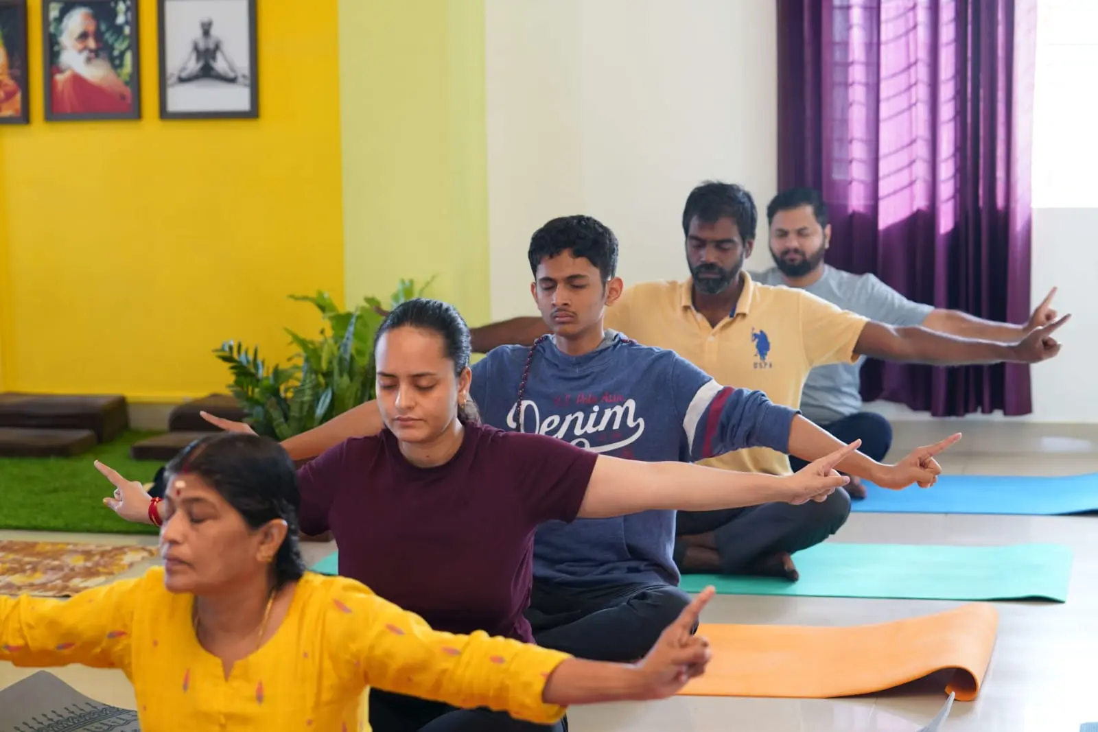 Students seated in a row extending their arms in a shared group practice